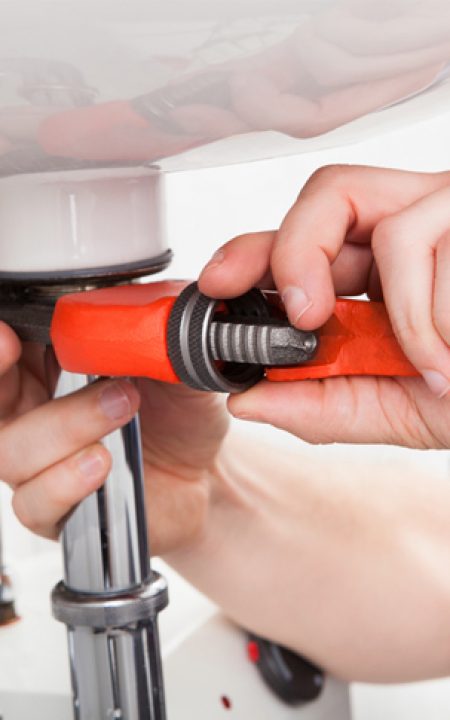 Tradesman Using a Wrench on a Sink Pipe - Plumbing & Gasfitting Services in Dubbo, NSW